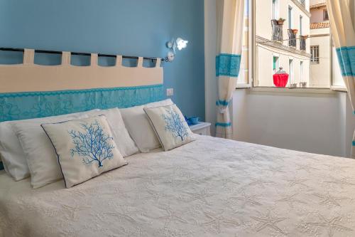 a bedroom with a bed with pillows and a window at Casa Vacanze San Michele in Alghero