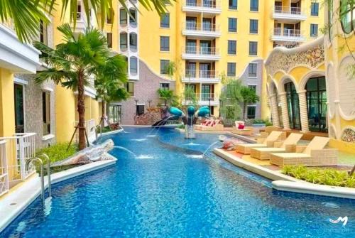 a pool in the middle of a building with a water slide at Espana Resort Pattaya Jomtien Beach in Jomtien Beach