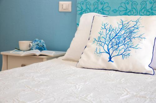 a bed with a pillow with a tree on it at Casa Vacanze San Michele in Alghero