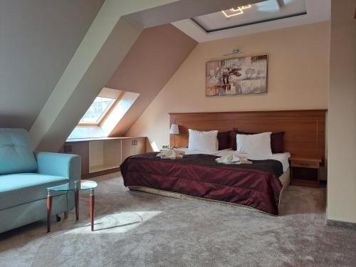 a bedroom with a bed and a blue chair at Contessa Hotel in Shumen