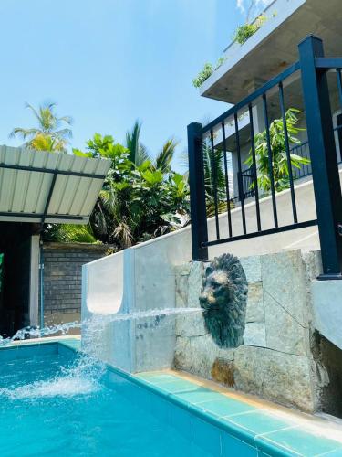 a lion head statue next to a swimming pool at Optimum Residencies in Negombo