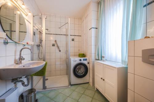 a bathroom with a sink and a washing machine at Haus Strandoase 27 in Bansin