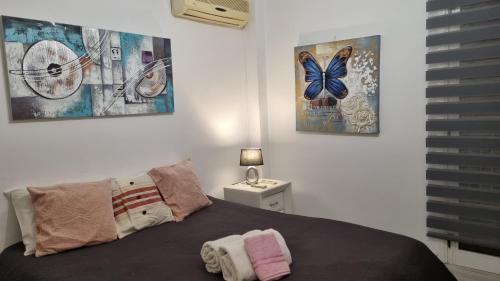 a bedroom with a bed and three pictures on the wall at Elpida Lemon Garden House in Limassol