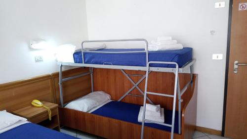 2 beliches num quarto com lençóis azuis e toalhas em Hotel Venezia Beach em San Mauro a Mare