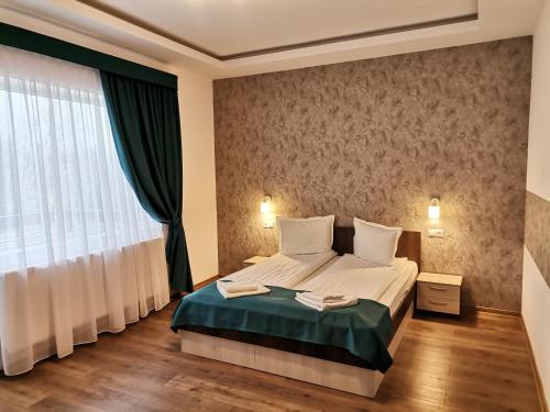 a bedroom with a bed and a large window at Vila President Sovata in Sovata