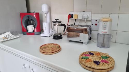 a kitchen counter with two cookies and appliances on it at Elpida Lemon Garden House in Limassol