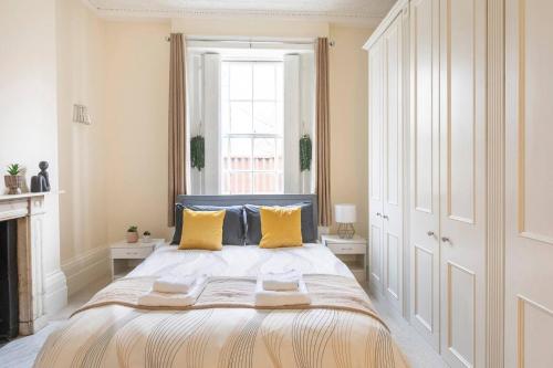 - une chambre avec un grand lit et des oreillers jaunes dans l'établissement Cozy Flat in the Heart of London, à Londres