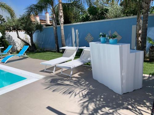 un patio con tavolo e sedie accanto alla piscina di B&B Villa Eraclea a Villaggio Mosè