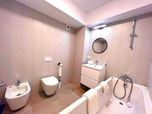ein Badezimmer mit einem Waschbecken, einem WC und einer Badewanne in der Unterkunft City Center Accommodation - 310 in Reşiţa