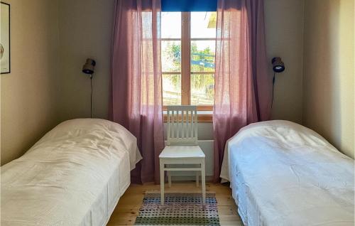 a bedroom with two beds and a chair and a window at 3 Bedroom Cozy Home In Långserud in Rullan