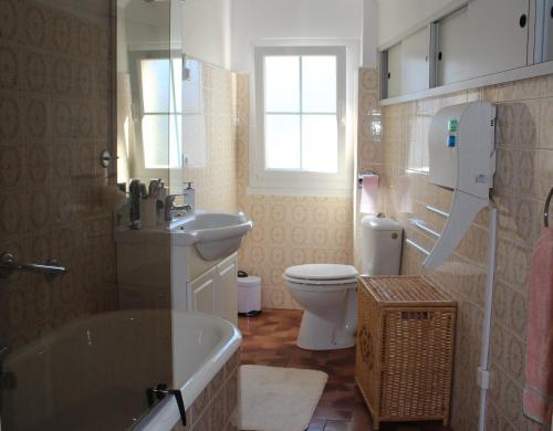 y baño con bañera, aseo y lavamanos. en GITE DU MOULIN, en Arudy