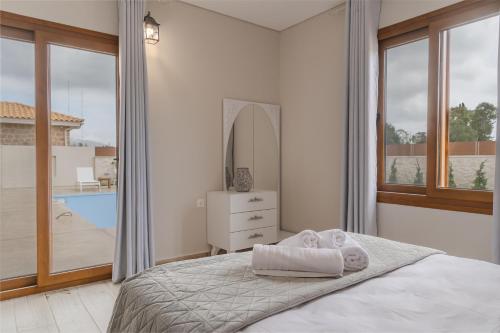 a white bedroom with a bed and a mirror at Villa Aqua - Laganas Stone Villas in Laganas