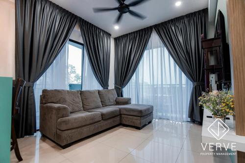 a living room with a couch and a ceiling fan at Ipoh Cove Premium Suites by Verve in Ipoh