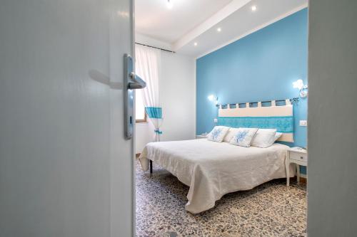 a bedroom with a bed and a blue wall at Casa Vacanze San Michele in Alghero