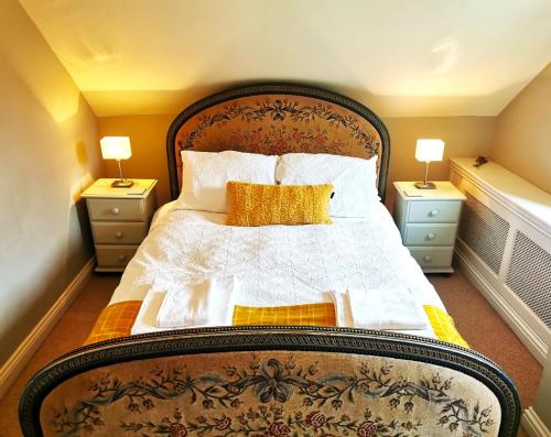 1 dormitorio con 1 cama grande y 2 mesitas de noche en Historic, traditional & Spacious Wiltshire Cottage, en Shrewton