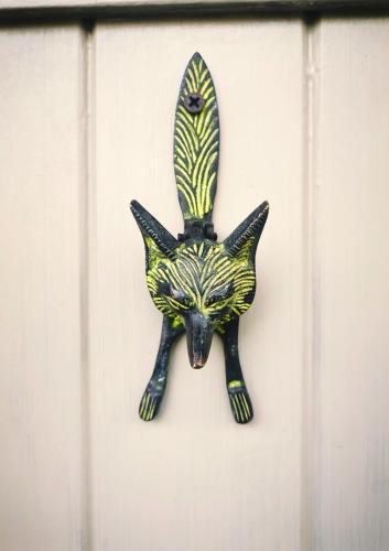 a black and yellow cat shaped object on a wall at Historic, traditional & Spacious Wiltshire Cottage in Shrewton