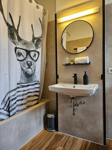 a bathroom with a sink and a deer wearing glasses at Landhotel Ölmühle in Mömbris