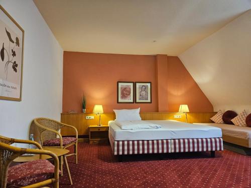 a hotel room with a bed and a table and chairs at Landhotel Ölmühle in Mömbris