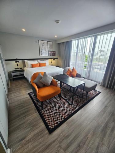 a hotel room with a bed and a table and chairs at Oakwood Residence Sukhumvit Thonglor Bangkok in Bangkok