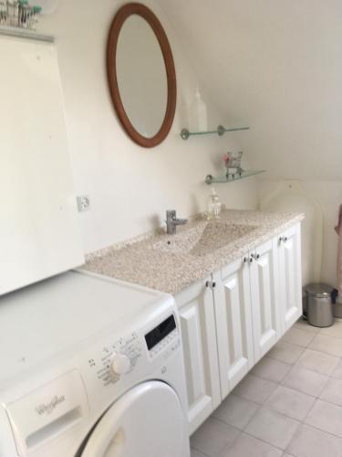 a bathroom with a washing machine and a mirror at Nationalpark Thy guesthouse in Vestervig