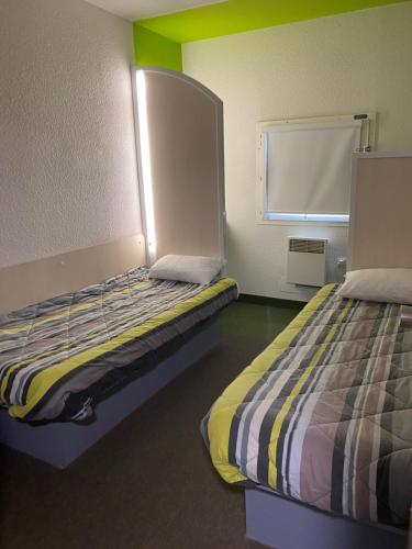 Cette chambre comprend 2 lits et une fenêtre. dans l'établissement HOTEL F1 SAINT-LO, à Saint Lo