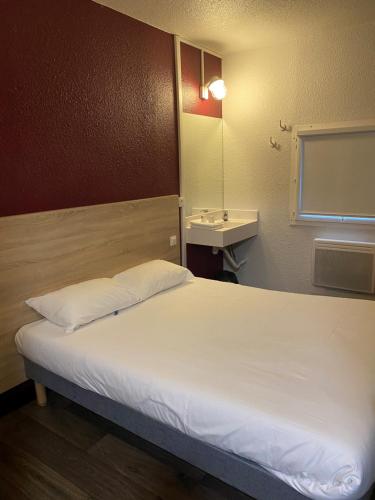 a bedroom with a large bed with a mirror and a sink at HOTEL F1 SAINT-LO in Saint Lo