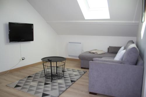 a living room with a couch and a table at GITE DU MOULIN in Arudy
