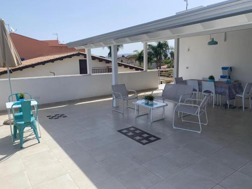 a patio with chairs and tables on a roof at La Terrazza di Eraclea in San Leone