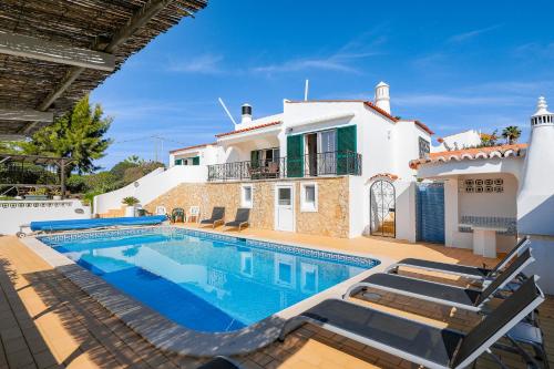 a villa with a swimming pool and a house at Casa Manjua in Carvoeiro
