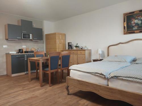 um quarto com uma cama, uma mesa e uma cozinha em Jennys Hofladen em Usedom Town