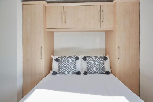 a bedroom with a white bed with wooden cabinets at Apartment 2, Khyber Lodge Apartment Whitby in Whitby