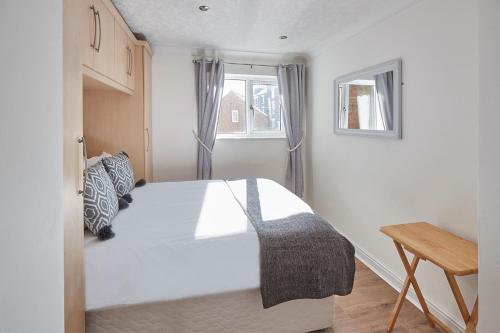 a bedroom with a white bed and a window at Apartment 2, Khyber Lodge Apartment Whitby in Whitby