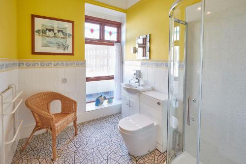 uma casa de banho com um chuveiro, um WC e um lavatório. em Apartment 3, Khyber Lodge Apartments Whitby em Whitby