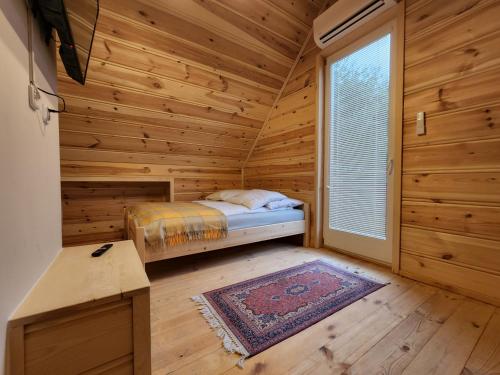a log cabin bedroom with a bed and a window at Agro-Gala in Rabka