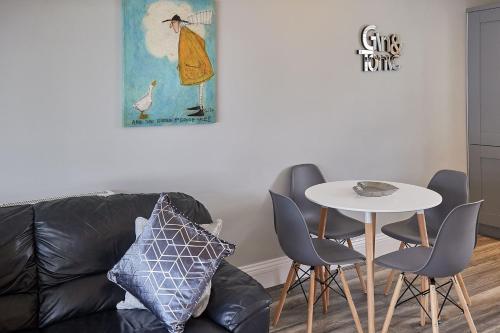 - un salon avec un canapé et une table avec des chaises dans l'établissement Apartment 4, Khyber Lodge Apartment Whitby, à Whitby