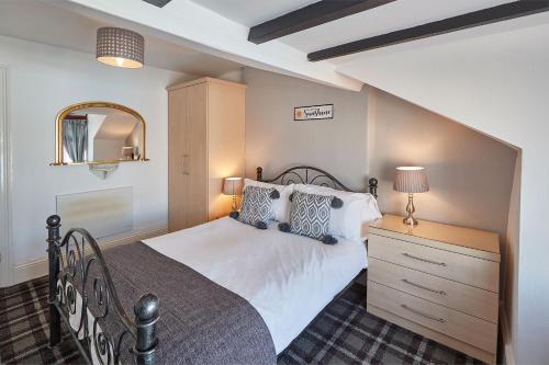 a bedroom with a bed and a dresser and a mirror at Apartment 4, Khyber Lodge Apartment Whitby in Whitby