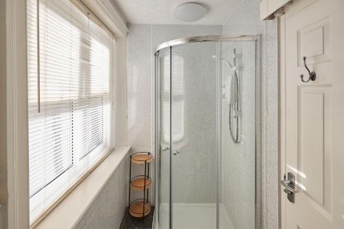 a bathroom with a shower with a glass door at Apartment 4, Khyber Lodge Apartment Whitby in Whitby
