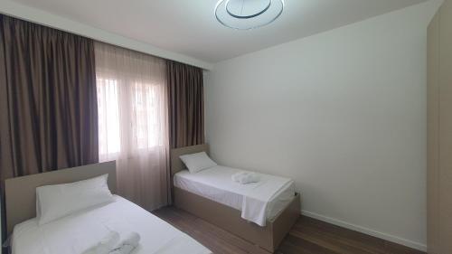 ein Hotelzimmer mit 2 Betten und einem Fenster in der Unterkunft Amelja's Apartment in Shkodra
