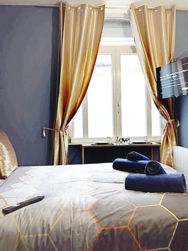 une chambre avec un lit avec des serviettes bleues dessus dans l'établissement LES MILLE & UNE NUITS ¤ PROCHE GARE ¤ NETFLIX, à Amiens