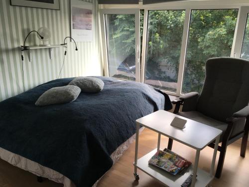 1 dormitorio con 1 cama, 1 silla y 1 ventana en Nationalpark Thy guesthouse, en Vestervig