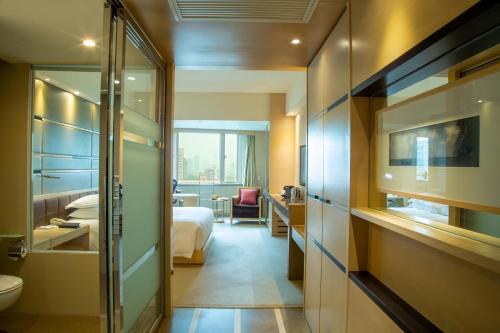 a hotel room with a bed and a bathroom at Hengshan Garden Hotel in Shanghai