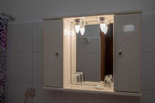 a bathroom with a mirror and a sink at Sea Breeze Hotel in Mastichari