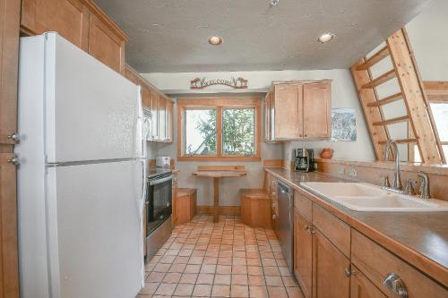 a kitchen with a white refrigerator and a sink at Cabin In The Pines 11 in Keystone