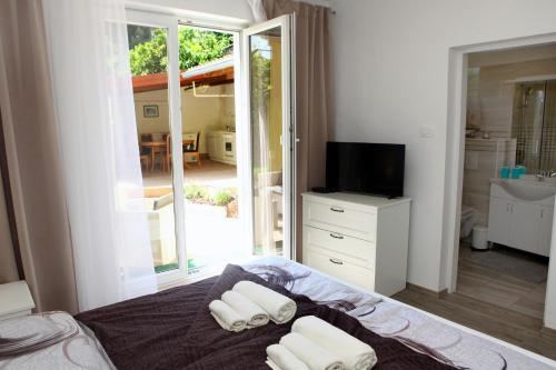 een slaapkamer met een bed met 2 kussens en een televisie bij Elegant Apartments BOP in Portorož