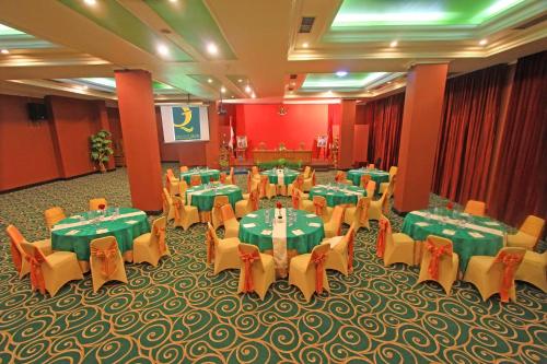 a banquet hall with green and yellow tables and chairs at Hotel Grand Q Gorontalo in Gorontalo