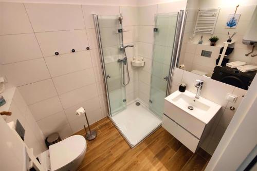 a bathroom with a shower and a toilet and a sink at Słoneczne Wybrzeże by Major Domus Club in Dziwnów