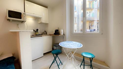 - une petite cuisine avec une table et deux tabourets dans l'établissement Bonaparte - Wifi, Hyper centre, 2 pers, à Nice