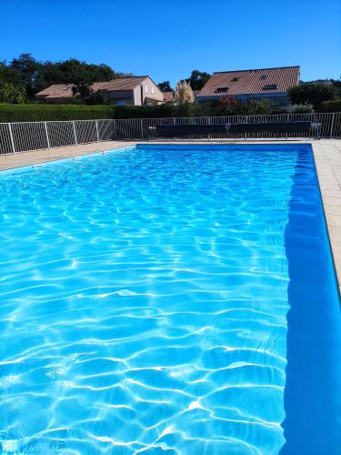 uma piscina com água azul em Charmante maison de vacances, 4P, piscines, proche Gohaud em Saint-Michel-Chef-Chef
