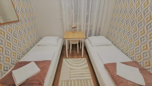 2 camas en una habitación pequeña con mesa en Schronisko Młodzieżowe PTSM Matecznik, en Przemyśl