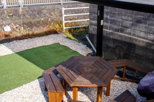 a small wooden table and bench in a yard at 伊豆の宿　静海 in Ito